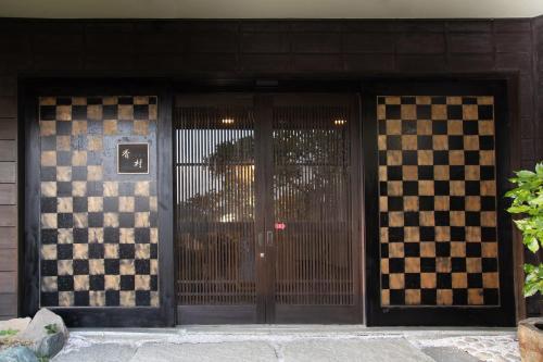 a door to a building with a checkerboard pattern at Matsushima Koumura in Matsushima