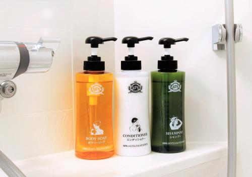 three bottles ofodorizers sitting on a shelf in a bathroom at APA Hotel Kagoshima Chuo-Ekimae in Kagoshima