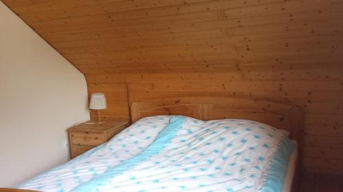 Pension Rosenblick في Mörlenbach: سرير في غرفة ذات سقف خشبي