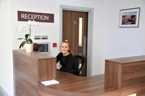 a woman sitting at a reception desk in a room at Belvedere Hotel and Golf in Bridlington