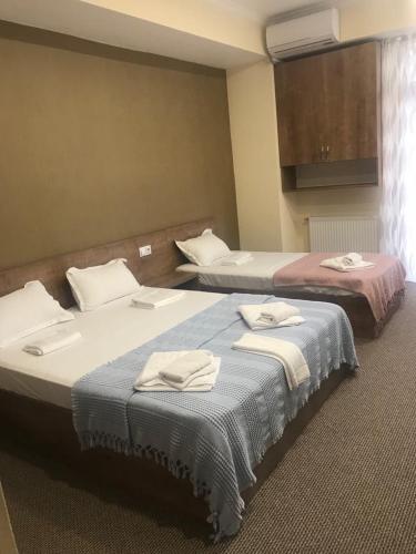 two beds in a hotel room with towels on them at 5 Rooms near 300 Aragveli metro station in Tbilisi City