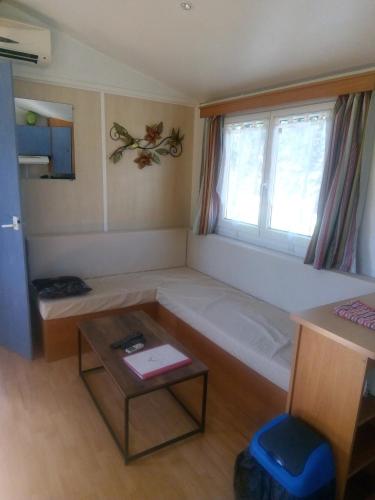 une chambre avec un lit, une table et une fenêtre dans l'établissement Les chalets de Bes Le Montagnol, à Lacombe