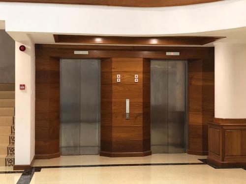 a hallway with three elevators in a building at Dragon Phoenix Hotel in Mandalay