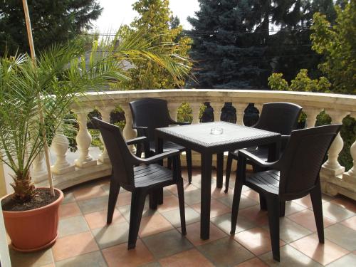 a table and chairs on a patio with a fence at Villa Rosa in Hajdúszoboszló