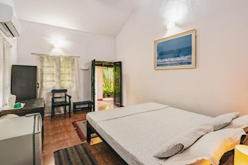 カラングートにあるRodrigues Guest Houseのベッドと薄型テレビのある寝室