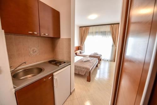 a small kitchen with a sink and a living room at Apartments Laguna in Ulcinj