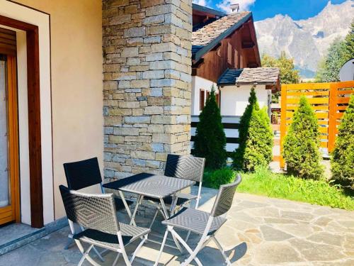 a table and chairs sitting on a patio at Green Park Studio Courmayeur in Courmayeur