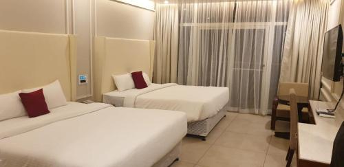 a hotel room with two beds and a window at Vythiri Village in Vythiri