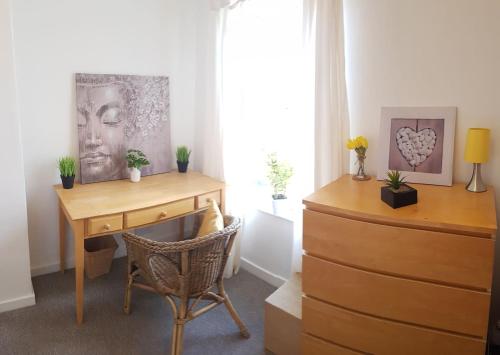 a room with a desk and a chair next to a window at Stylish and homely space with considered work area in Norwich