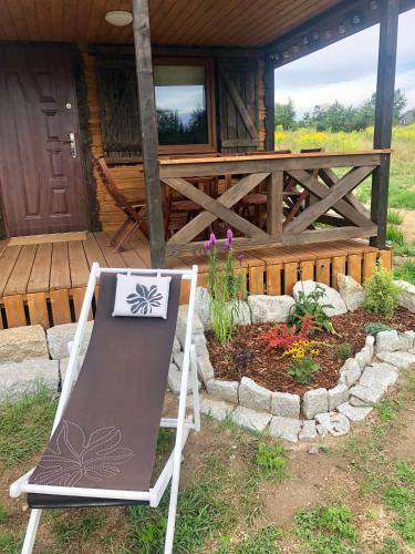 a chair sitting outside of a cabin with a garden at Browarówka in Łomnica