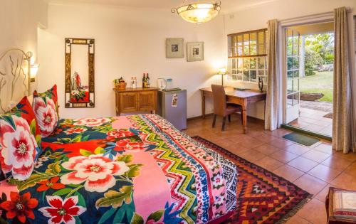 1 dormitorio con 1 cama con colcha colorida en Jacana Gardens, en Harare