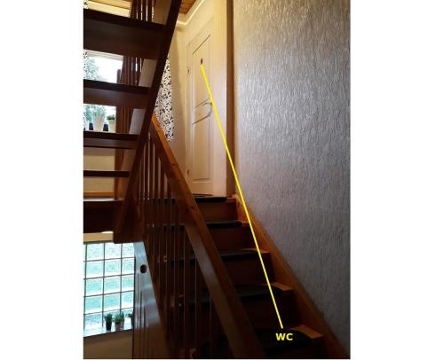 a yellow hose is on the wall next to a stairs at Gästezimmer Wagner in Meckenbeuren