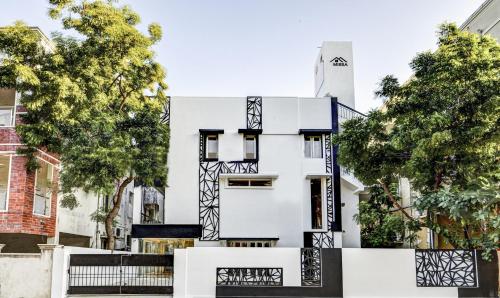 uma casa branca com arquitectura a preto e branco em Itsy By Treebo - Mirra em Chennai