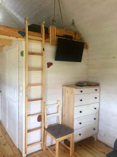 a bedroom with a bunk bed and a chair and a dresser at Browarówka in Łomnica