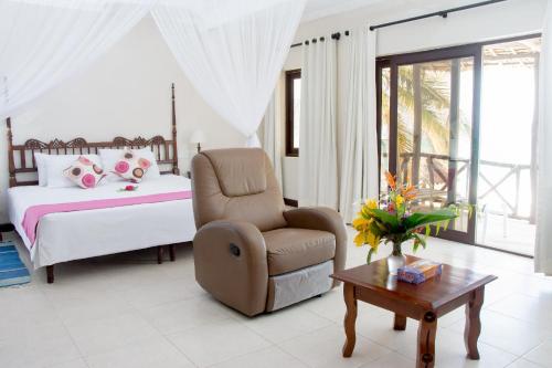 
a living room filled with furniture and a table at Jacaranda Indian Ocean Beach Resort in Diani Beach
