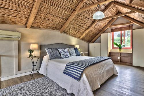 a bedroom with a bed and a wooden ceiling at The Beach Loft in Hout Bay