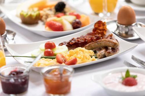 a table with plates of breakfast food on it at Vital Resort Mühl in Bad Lauterberg