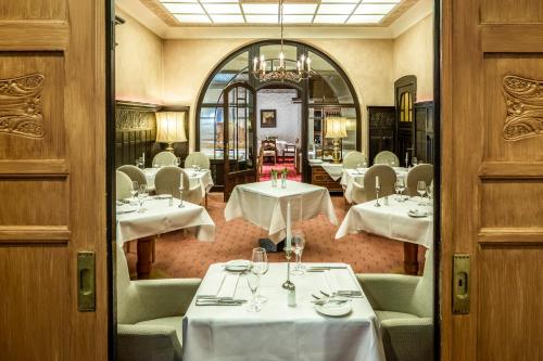 a restaurant with white tables and chairs and a mirror at Vital Resort Mühl in Bad Lauterberg