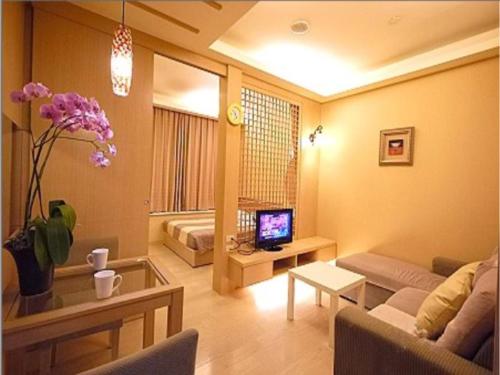 a living room with a couch and a tv at 85 Cape Inn in Kaohsiung