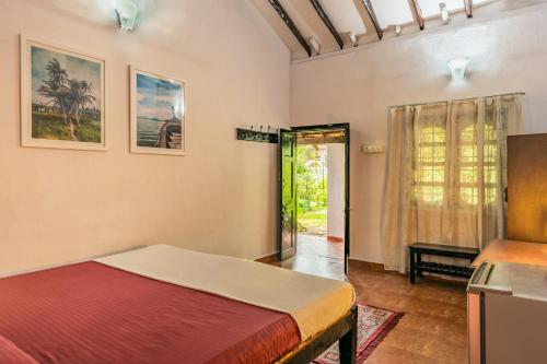 a bedroom with a bed and a door to a yard at Rodrigues Guest House in Calangute