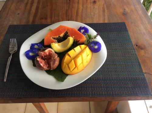 a plate of fruit on a table with a fork at Vi Miles Lodge in Mahe