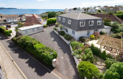 an aerial view of a house with the ocean in the background at Three Beaches Holiday Apartments - close to Goodrington beach in Paignton in Paignton