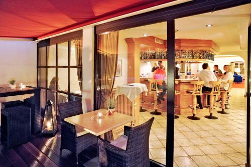 a restaurant with a table and people sitting at a bar at Vital Resort Mühl in Bad Lauterberg