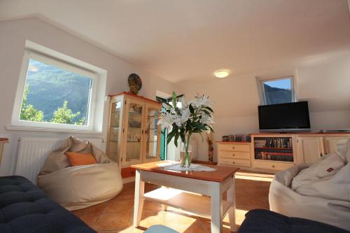 a living room with a vase of flowers on a table at Apartment Pri Leju in Srpenica