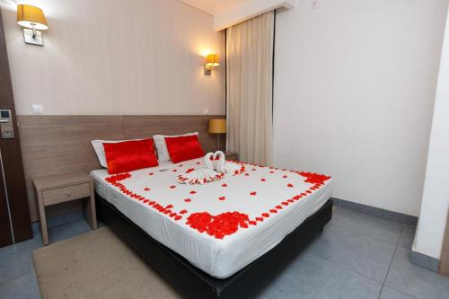 a bedroom with a bed with red flowers on it at Hotel Santa Cruz in Maputo