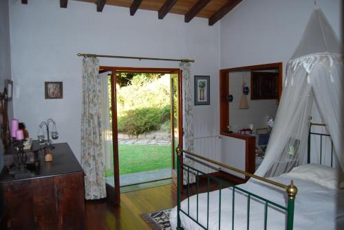 a bedroom with a bed and a sliding glass door at Casa Dos Canais, River Cottage in Marco de Canaveses