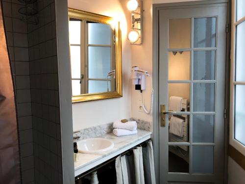 La salle de bains est pourvue d'un lavabo et d'un miroir. dans l'établissement Entre Terre Et Mer, à Honfleur