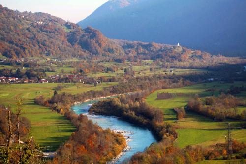a river in the middle of a valley with a mountain at Apartment Pri Leju in Srpenica