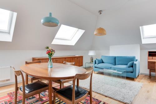 a living room with a table and a blue couch at Newton Boutique Hotel Residences - Brussels EU Area in Brussels