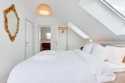 a white bedroom with a large bed with white pillows at Newton Boutique Hotel Residences - Brussels EU Area in Brussels