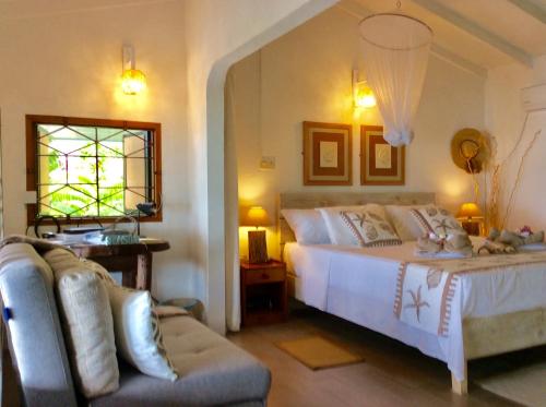 sypialnia z łóżkiem i kanapą w obiekcie Vi Miles Lodge w Mahé