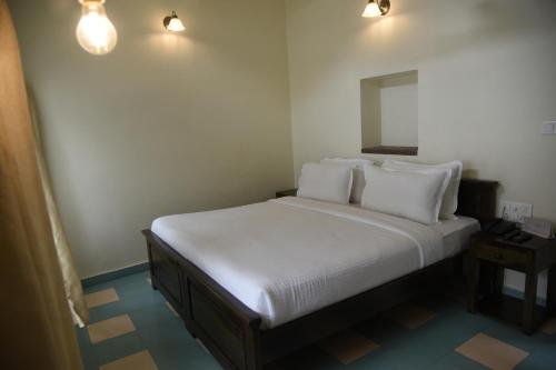 a bed with white sheets and pillows in a room at Baijoo Niwas in Jodhpur
