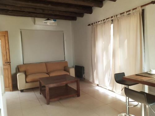 sala de estar con sofá y mesa en Viamonte Rest Depto en Ciudad Lujan de Cuyo