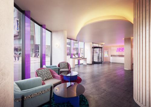 a lobby with chairs and tables in a building at YOTEL Glasgow in Glasgow