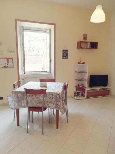 a dining room with a table and chairs and a window at Nido d'amore in Anagni