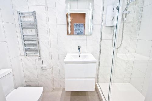 ein weißes Bad mit einem Waschbecken und einer Dusche in der Unterkunft Eldon Chambers Pod 7 by City Living London in London