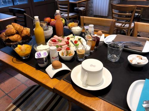ein Tisch mit Frühstücksspeisen und Getränken darauf in der Unterkunft Entre Terre Et Mer in Honfleur