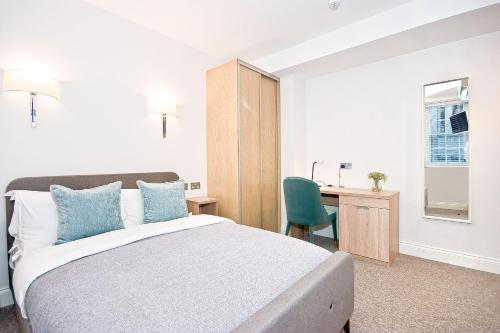 a bedroom with a bed and a desk with a chair at Eldon Chambers Pod 6 by City Living London in London