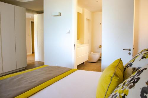 a bedroom with a bed with yellow pillows at Manta Cove by Horizon Holidays in Tamarin