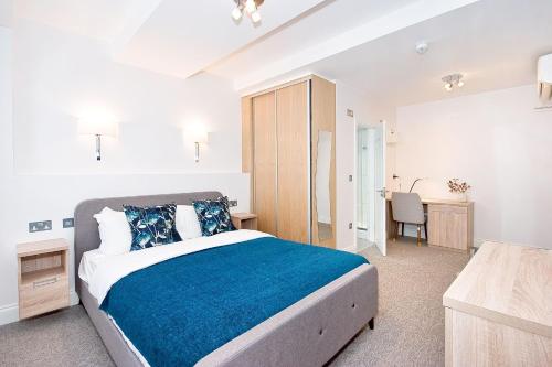 una camera da letto con un grande letto con una coperta blu di Eldon Chambers Pod 5 by City Living London a Londra