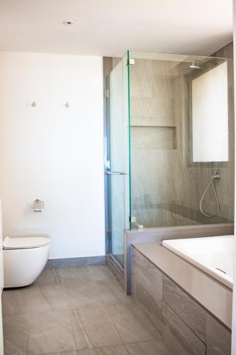 a bathroom with a tub and a toilet and a sink at Manta Cove by Horizon Holidays in Tamarin