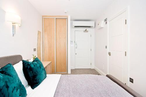 Eldon Chambers Pod 4 by City Living London في لندن: غرفة نوم مع سرير ووسائد زرقاء