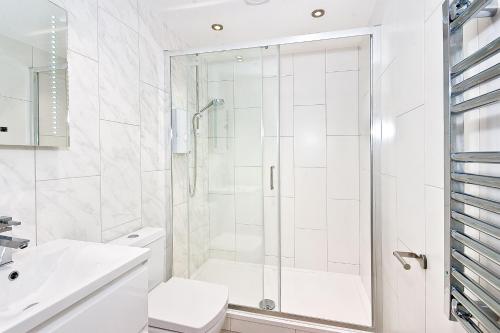a white bathroom with a shower and a toilet at Eldon Chambers Pod 4 by City Living London in London