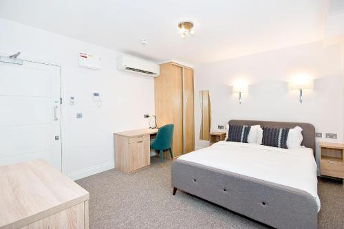 1 dormitorio con cama, escritorio y silla en Eldon Chambers Pod 3 by City Living London en Londres