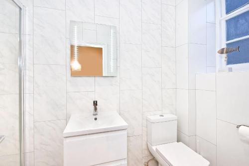 een witte badkamer met een toilet en een wastafel bij Eldon Chambers Pod 2 by City Living London in Londen