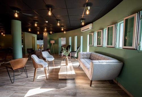 a living room with a couch and chairs at PoMo Hôtel & Restaurant in Échirolles
